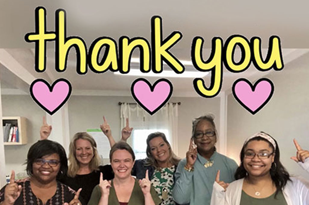 A group of women holding up one finger with the text "Thank You" above them.